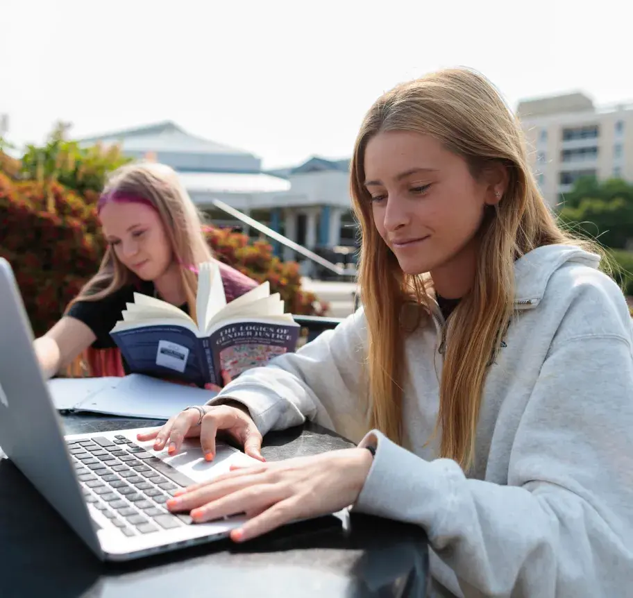 Students reading and using laptop