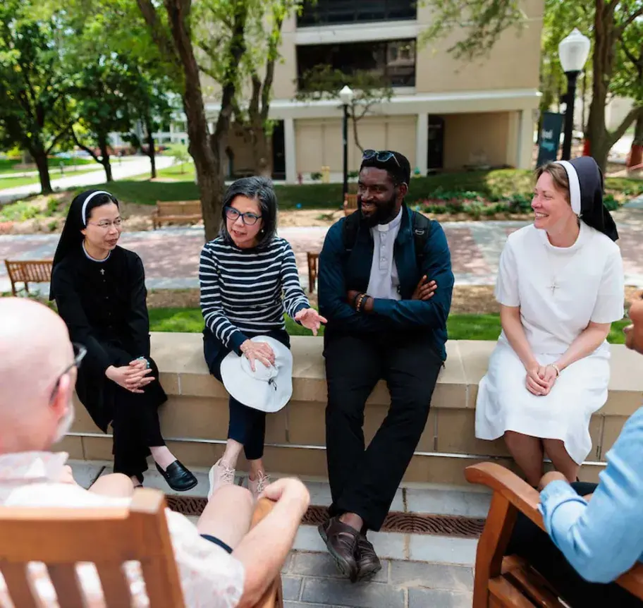 students sitting on campus talking and smiling