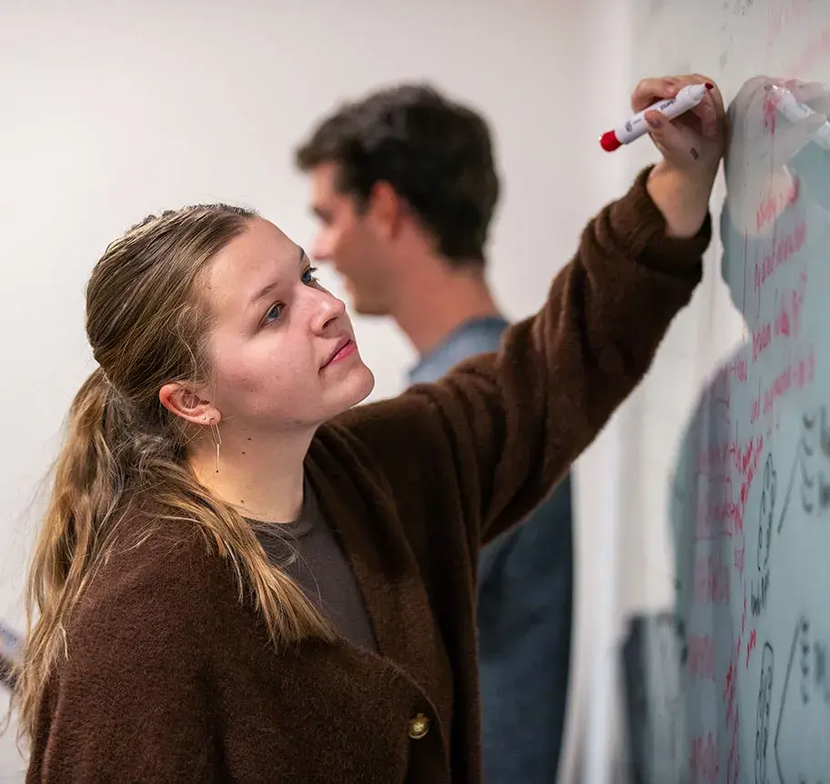 Physics student using whiteboard