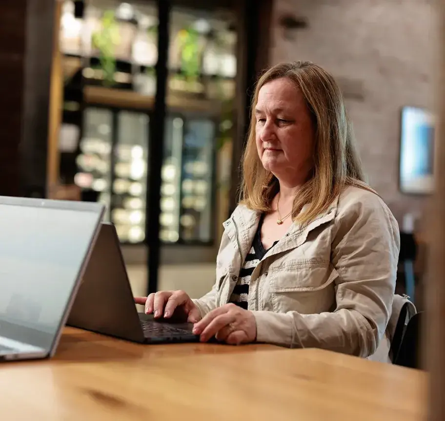 EMS management worker studying at laptop.
