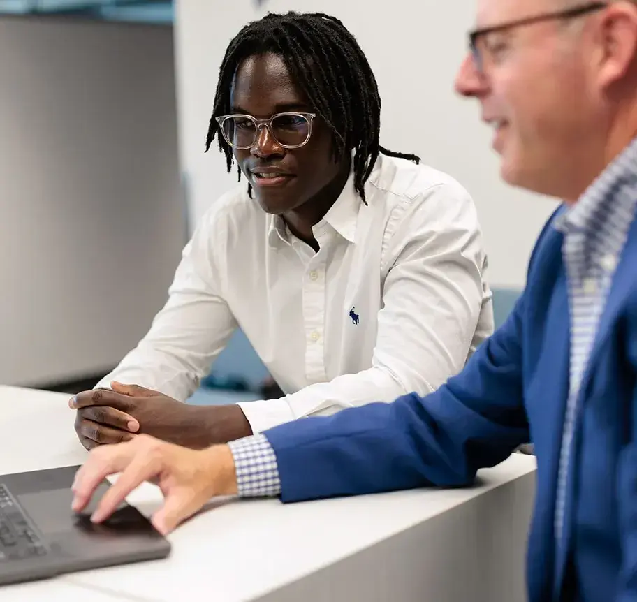 Student working with advisor on laptop