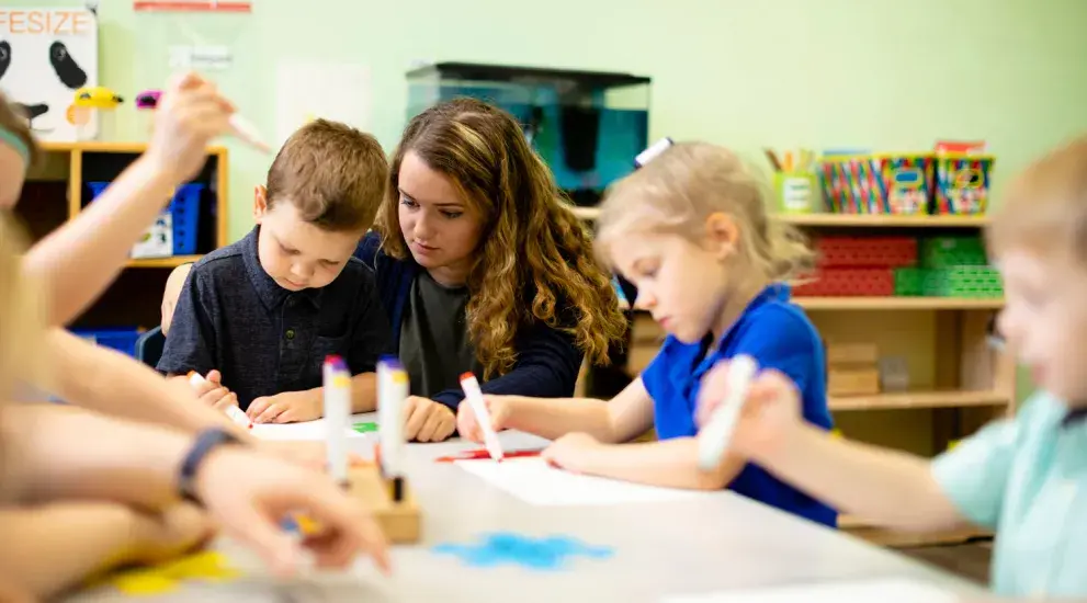 Student teacher working with children in classroom