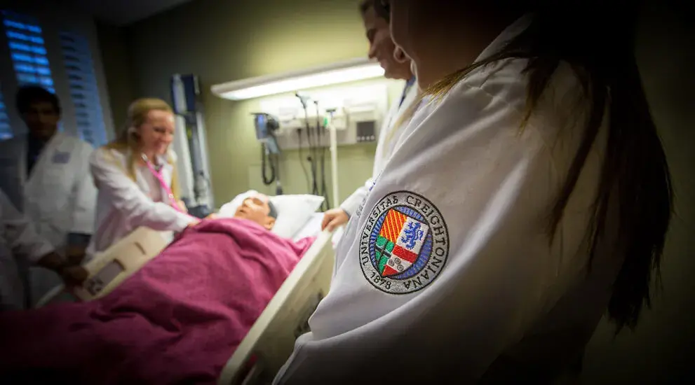 Close up of the Creighton University crest on the sleeve of a medical student's white coat