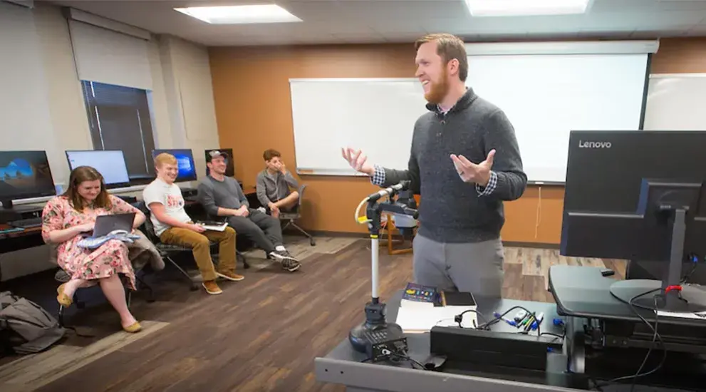 A professor lecturing a group of students during a lab