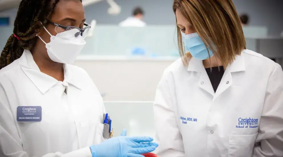 Dean Wallen in lab setting with another woman wearing masks and gloves.