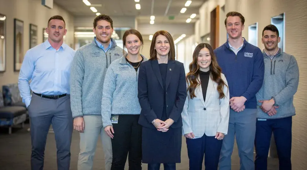 Dean Wallen with dental students posing for photo smiling.