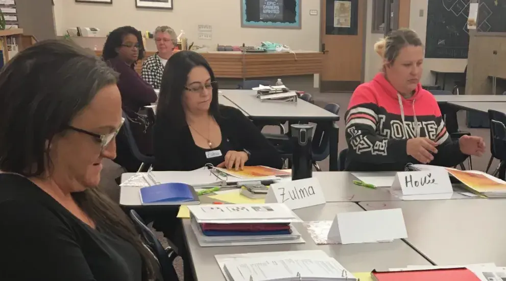Women attending financial class seated at table.