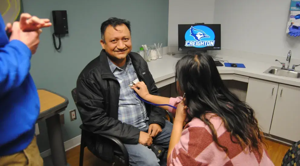 student with stethoscope listening to her dads chest