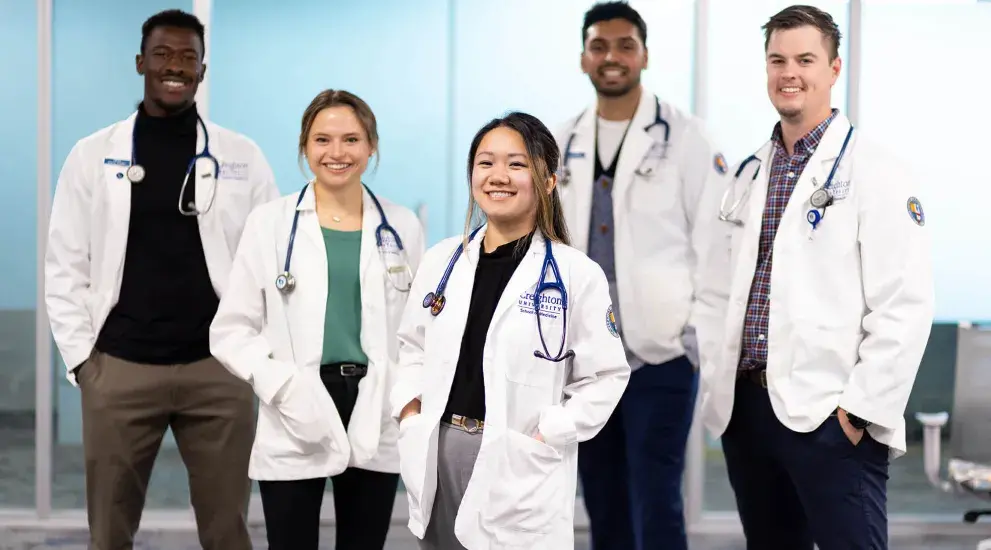 diverse medical students with white jackets and stethoscopes