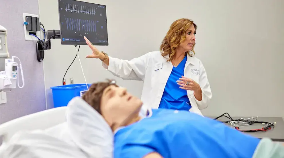 Caregiver practicing with simulation patient in lab.