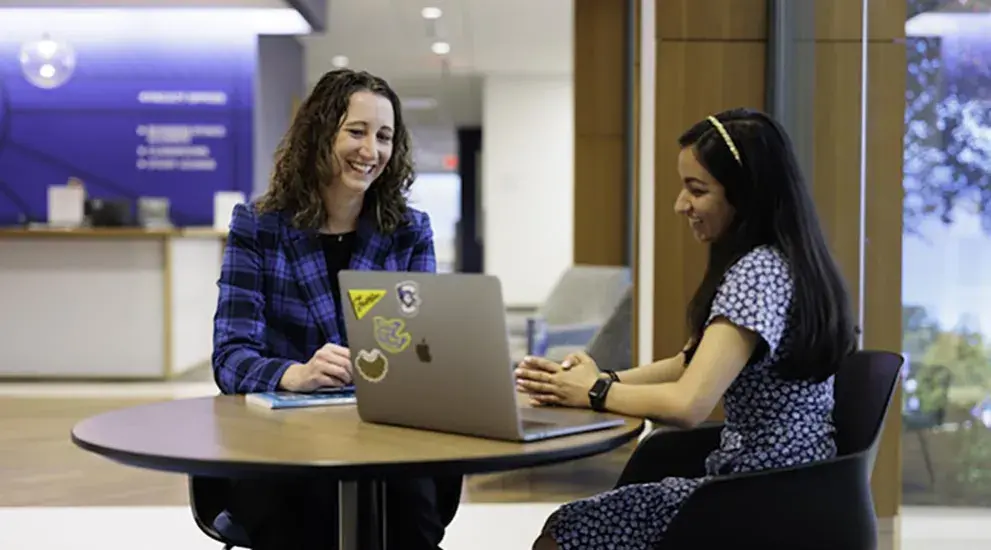 Two students studying in communal space at Heider College of Business.