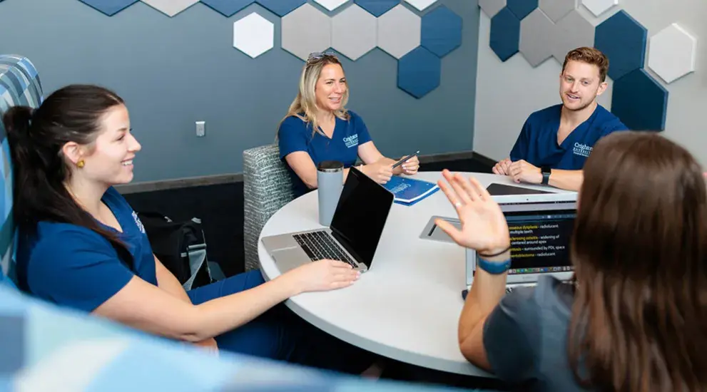 Dental students talking around desk