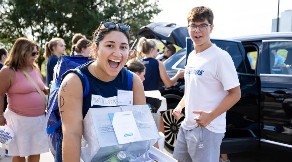 Students carrying boxes into residence halls.