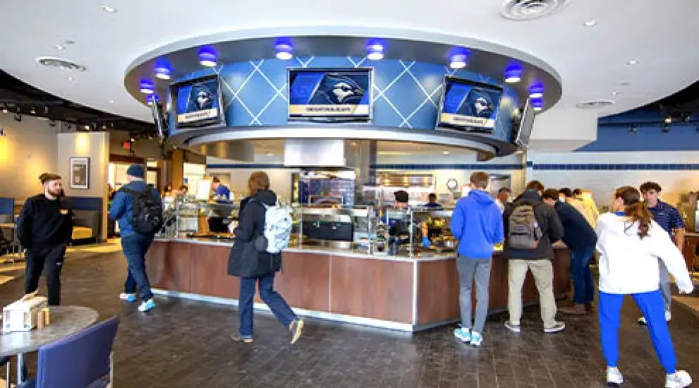 Students gathering in dining hall setting.