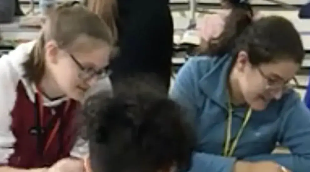 Katelyn Grzelak working at table with fellow student.
