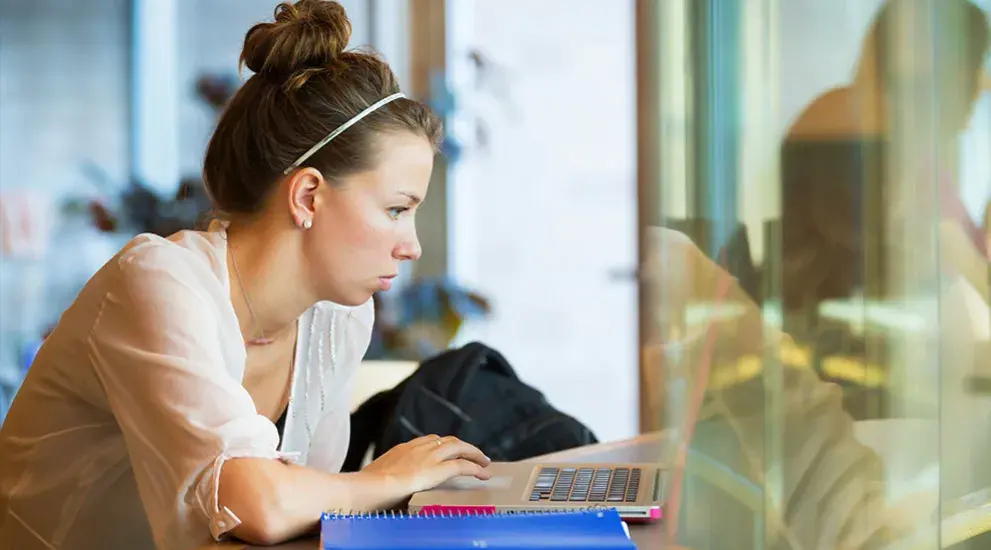 student on laptop sitting at a table