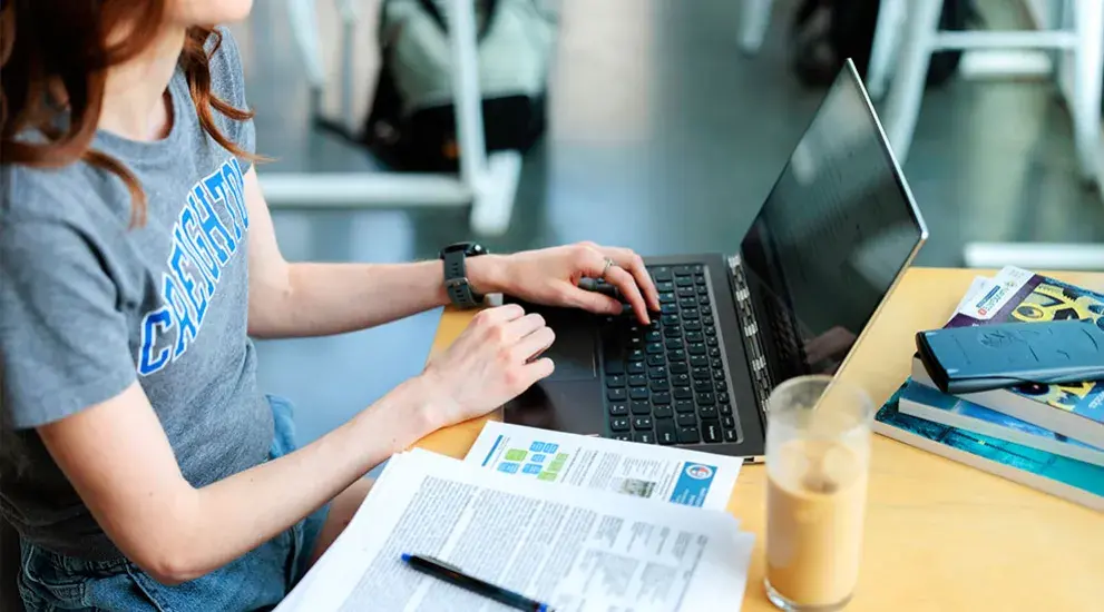 student on laptop sitting at a table