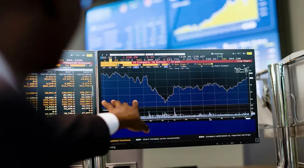 Person examining economics data on terminal station display.
