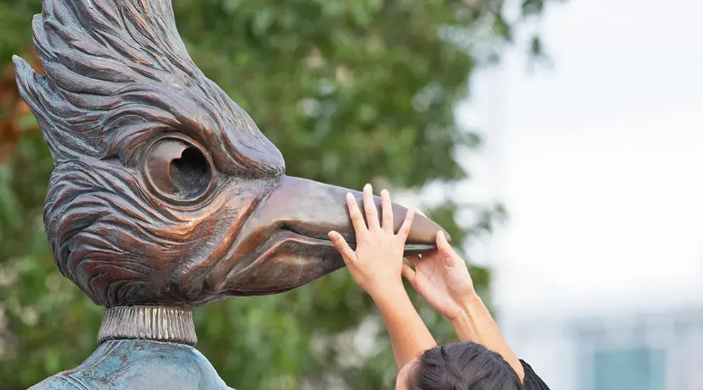 students touching beak of Billly Bluejay statue
