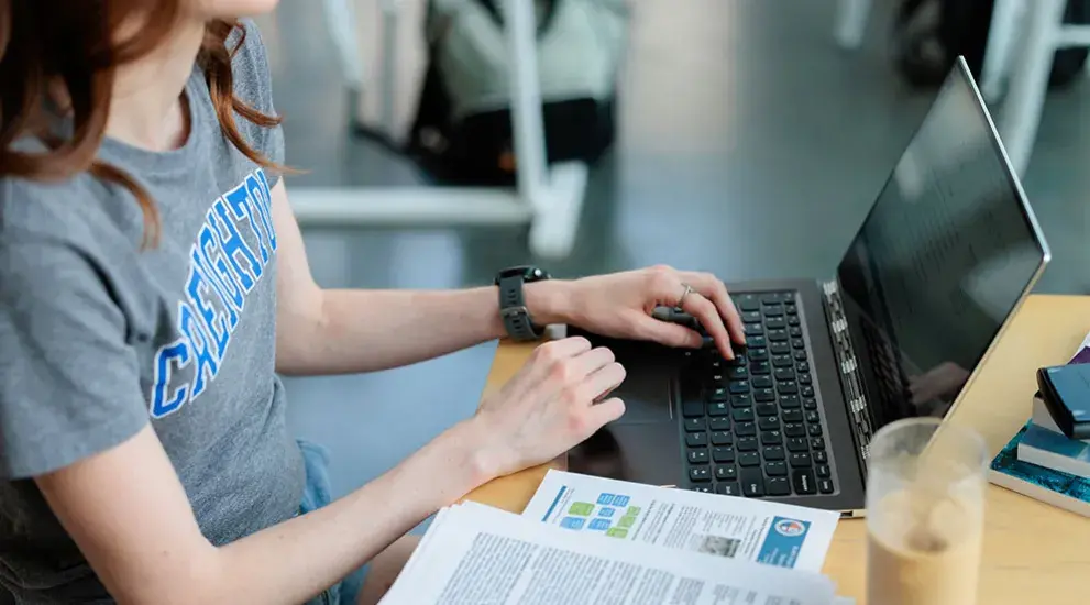 student on laptop sitting at a table