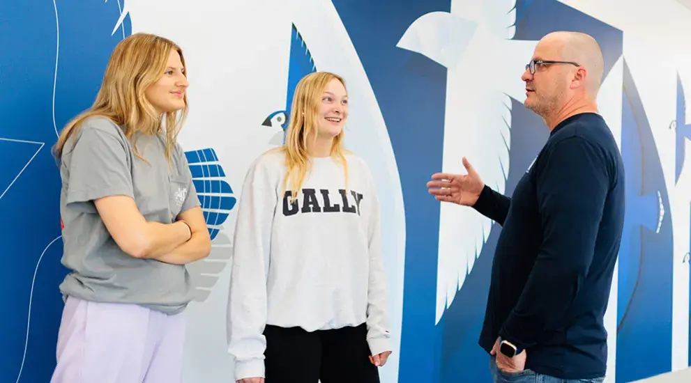 Two students talking with a faculty member