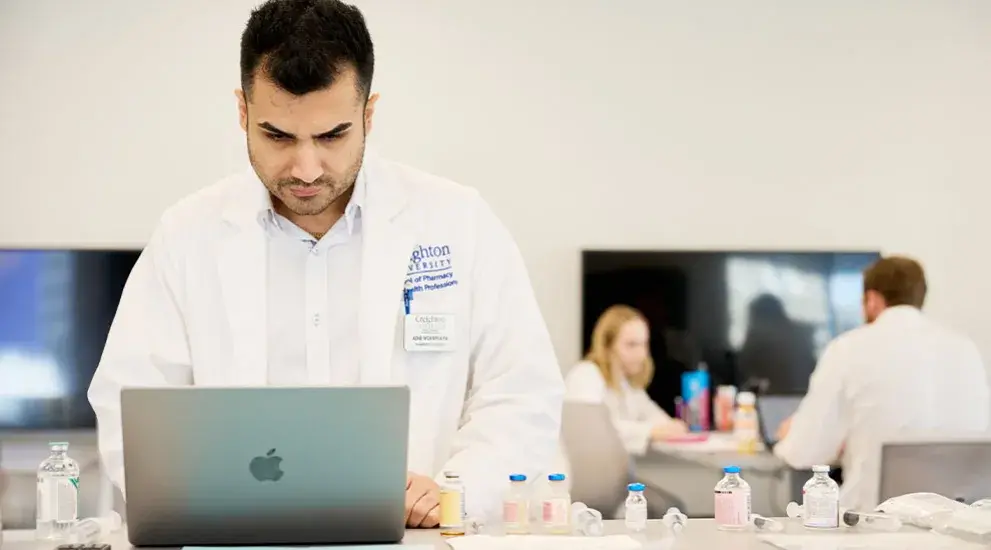Pharmacy student working at laptop