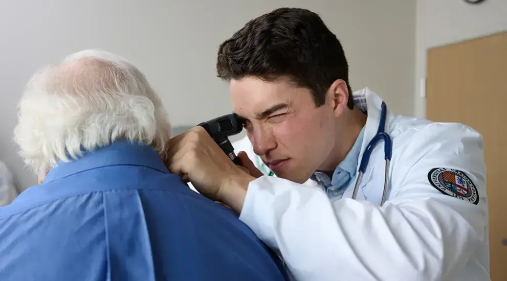 Medical student examining patient ear