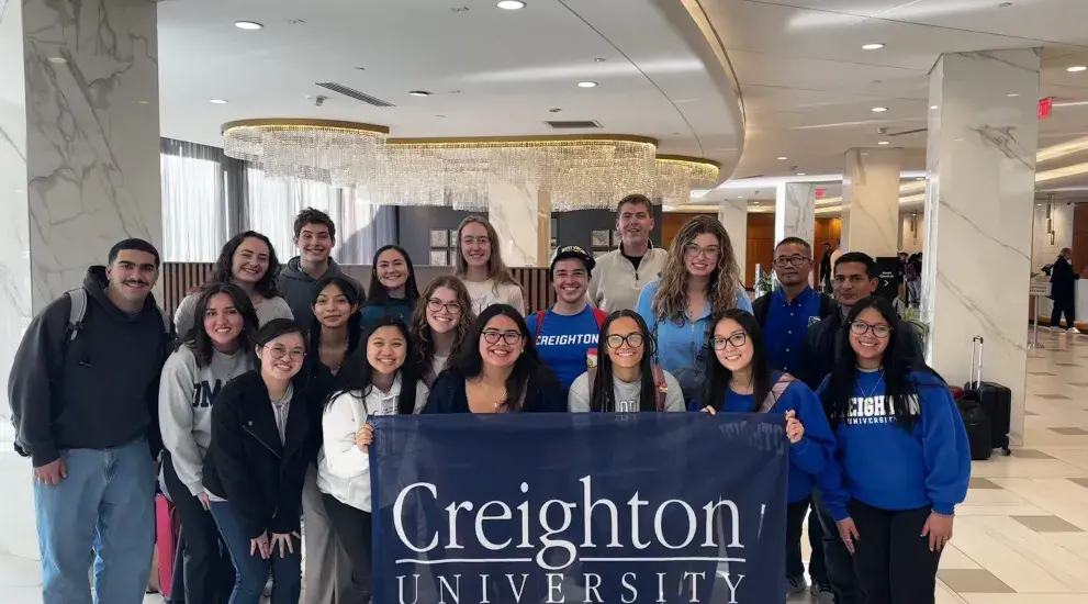 Group photo of students with Creighton flag