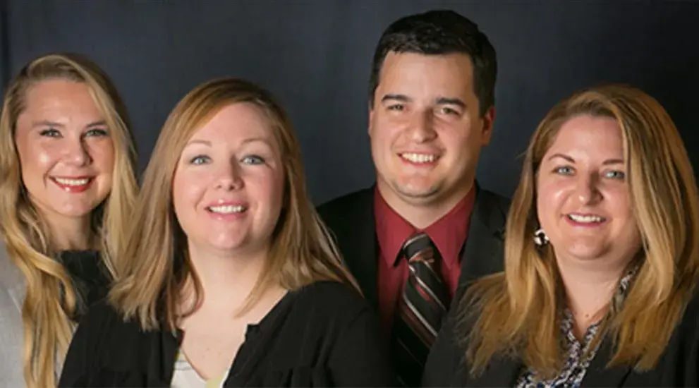 2018 General Surgery Residency graduation photo featuring four residents in business formal attire celebrating their program completion.