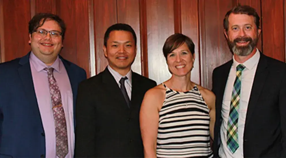 2023 General Surgery Residency graduation photo featuring four residents in business formal attire celebrating their program completion.