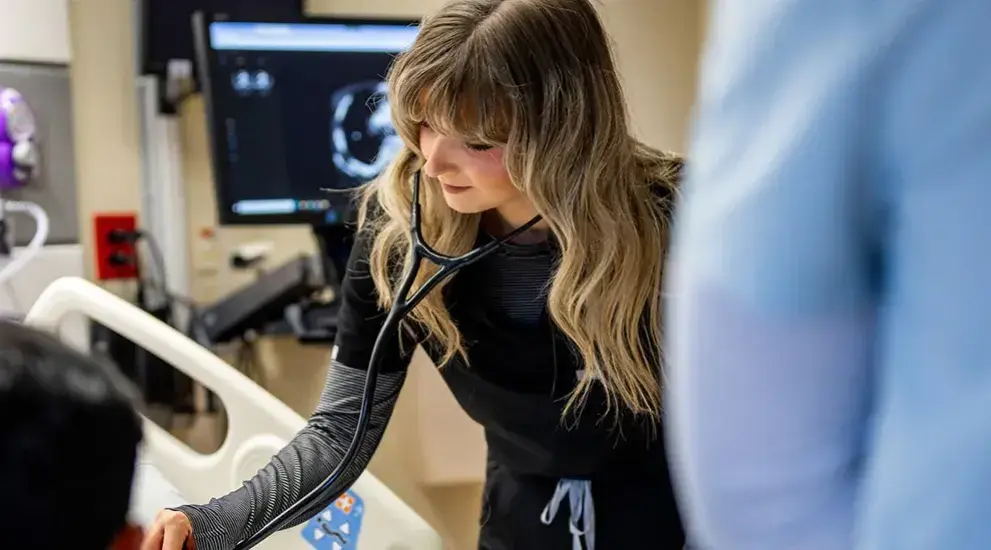 Fellow checking patient with a stethoscope