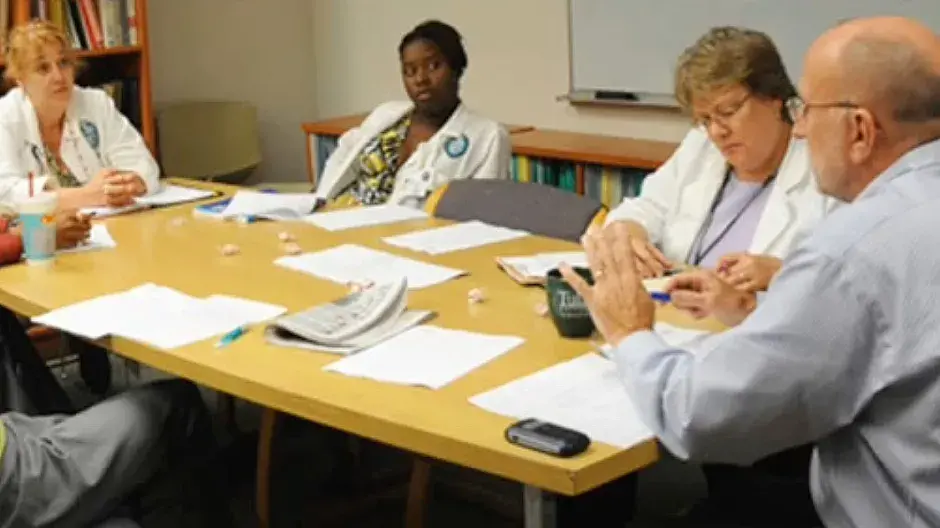 Nursing professionals talking at conference table.