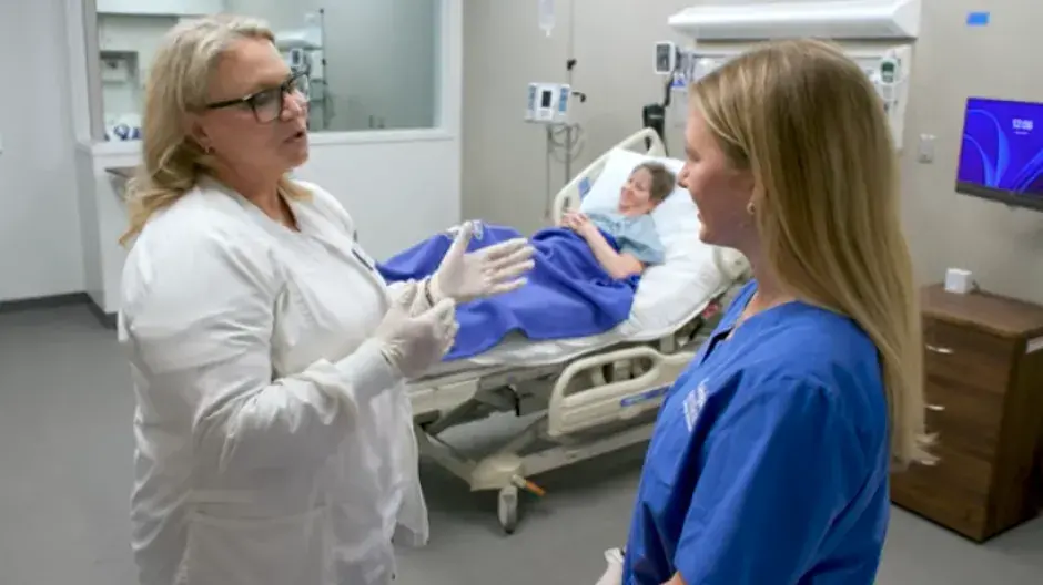 Faculty and student talking in a patient's room